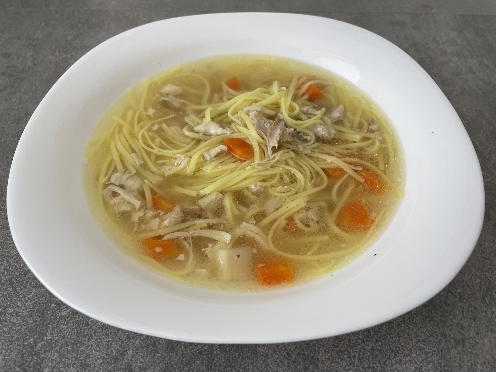 Hotový kuřecí vývar na talíři